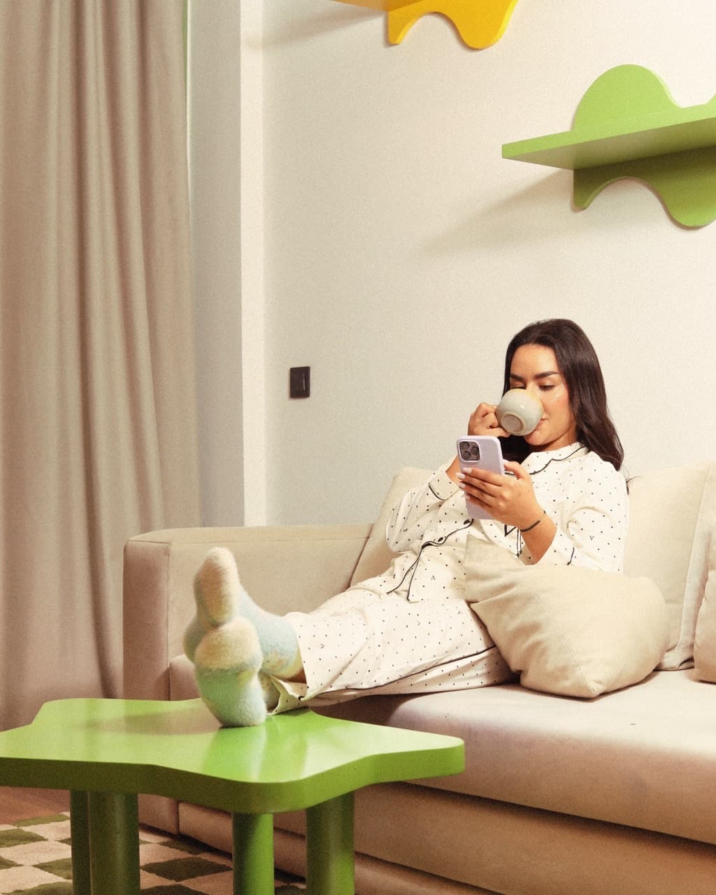 Guest cozy on couch with coffee and phone